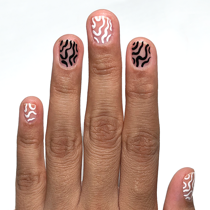 Blank Canvas white liner used for white and black squiggle nail art on a medium skin tone