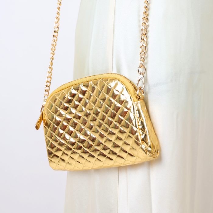 a gold purse on a white dress