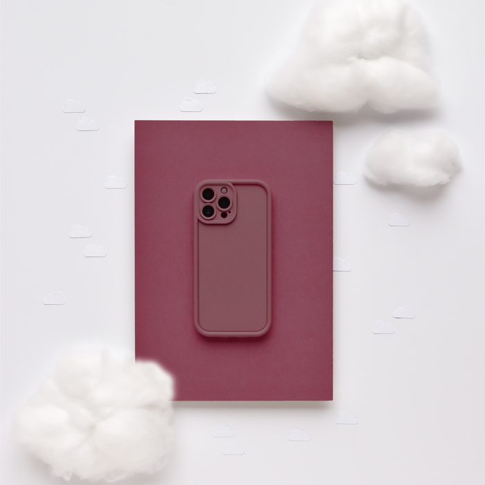 Burgundy Cloud Soft NAKD phone case by Coconut Lane on white clouds with playful paper cutouts.
