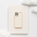 Beige iPhone with a soft, cream-colored Coconut Lane phone case set on fluffy clouds with simple illustrations.