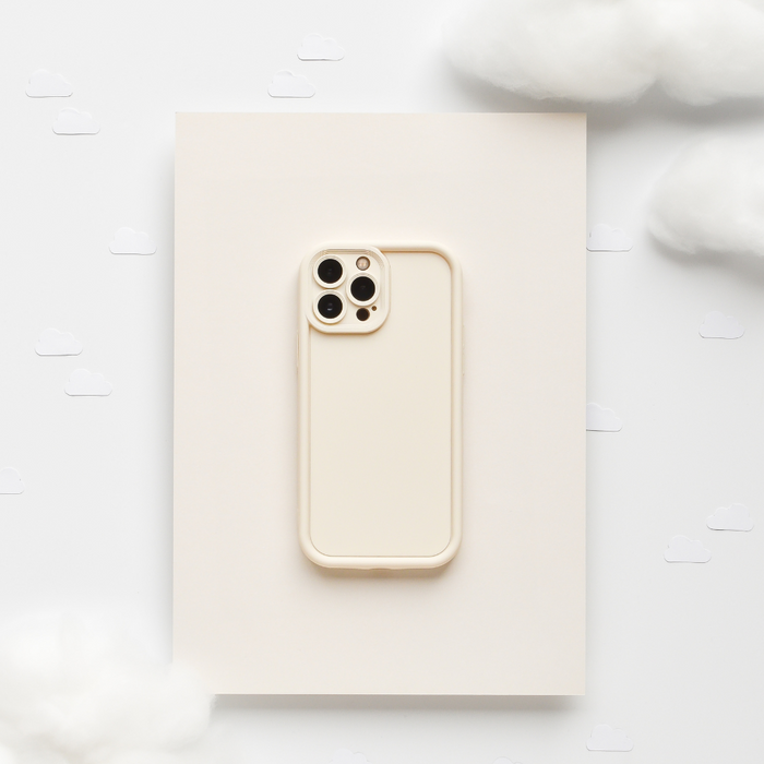 Beige iPhone with a soft, cream-colored Coconut Lane phone case set on fluffy clouds with simple illustrations.