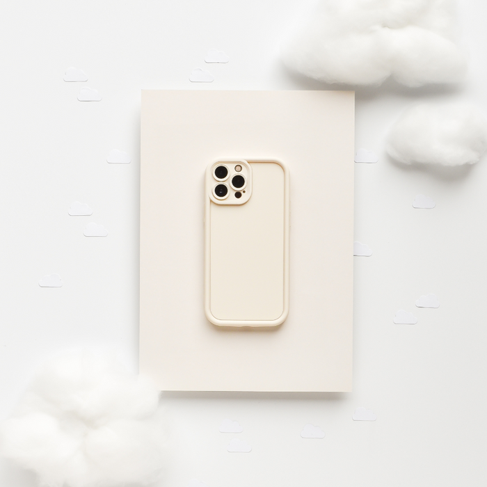 Beige iPhone in a Coconut Lane Cloud Soft NAKD Phone Case, cashmere cream color, on a soft light background.
