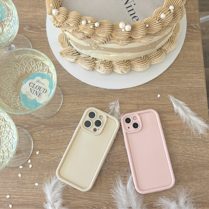 Cashmere cream and beige Cloud Soft NAKD phone cases with CLOUD NINE glasses on a wooden table.