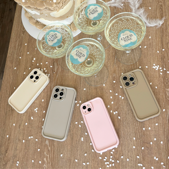 Pebble beige phone cases and “Cloud Nine” glasses arranged on a wooden table.