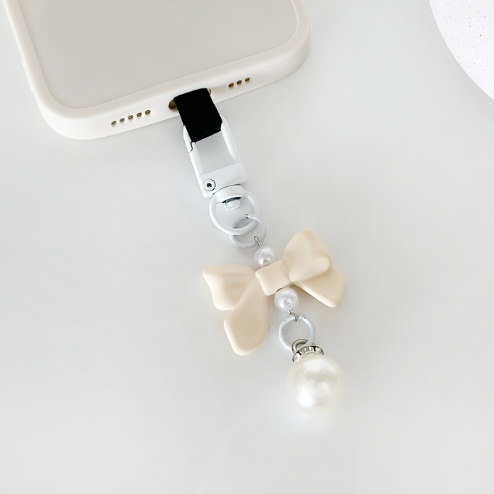 Cream Coquette Bow phone keyring bundle from Coconut Lane attached to a white phone case.