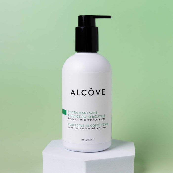White bottle of Alcôve Hair Curl Leave-In Conditioner on a light green background