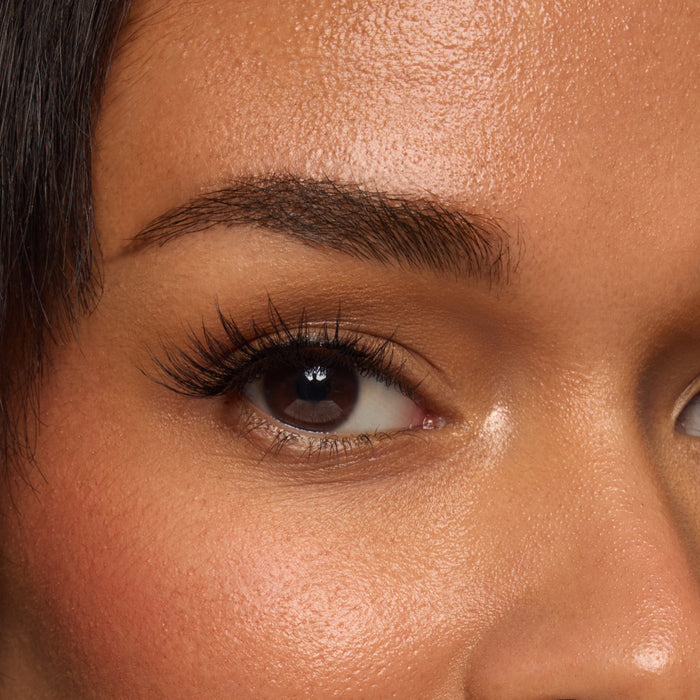 Macro shot of a model forehead with visible skin texture and a well groomed eyebrow