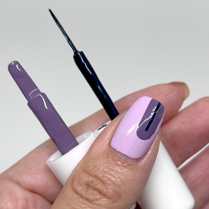 Drawing a stripe on a lavender nail with the Ink-redible black liner brush