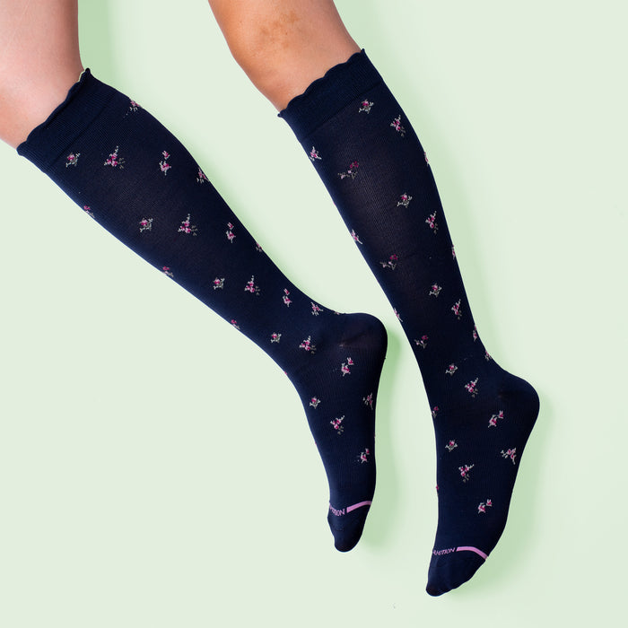 Navy knee-high compression socks with a floral pattern and scalloped top.