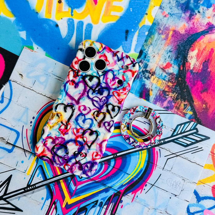 Love Out Loud colorful graffiti heart pattern MagSafe phone grip ring with overlapping neon pink purple and turquoise hearts compatible with iPhone and Samsung