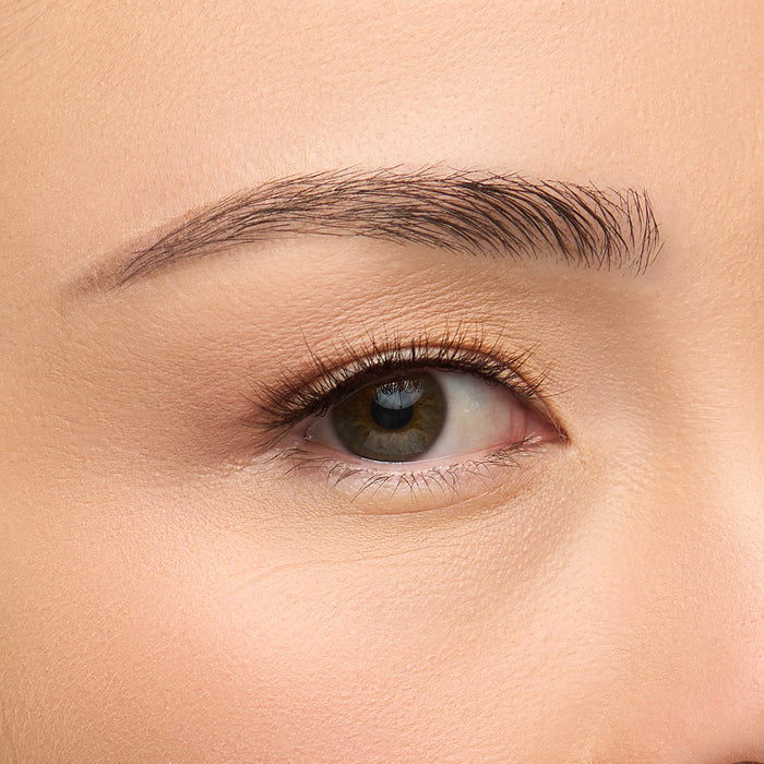 Macchiato a short natural lash with denser outer corners and wispy texture for an everyday look, featuring a unique blend of black, brown, and red wine fibers shown on an eye.