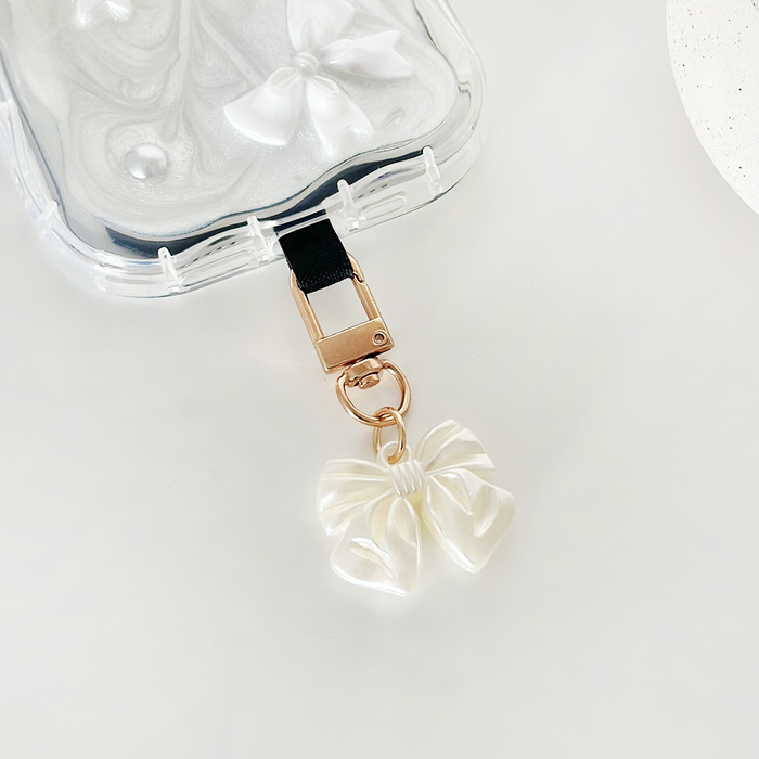 Clear marble phone case with pearlescent bow charm keyring from Coconut Lane.