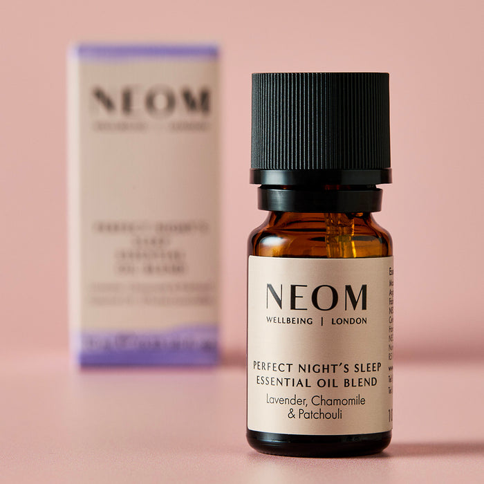 NEOM Perfect Night’s Sleep essential oil blend bottle with its box softly blurred behind it.