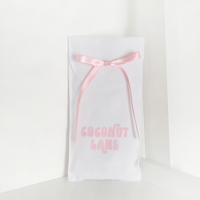 Coconut Lane phone case gift pouch with pink lettering and ribbon on a simple, eco-friendly fabric.