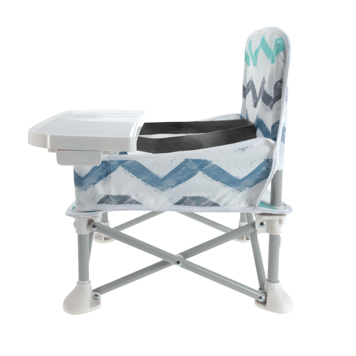 The Nuby Pop Up Booster Seat | Chevron is a foldable travel high chair with a tray, backrest, and sturdy legs with white feet. Featuring a white, blue, and gray zigzag pattern, it's perfect for feeding young children on the go.