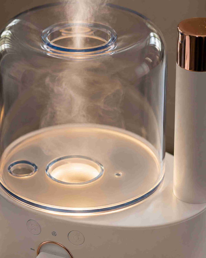 Glass dome aroma diffuser top with mist outlet and circular light ring detail.