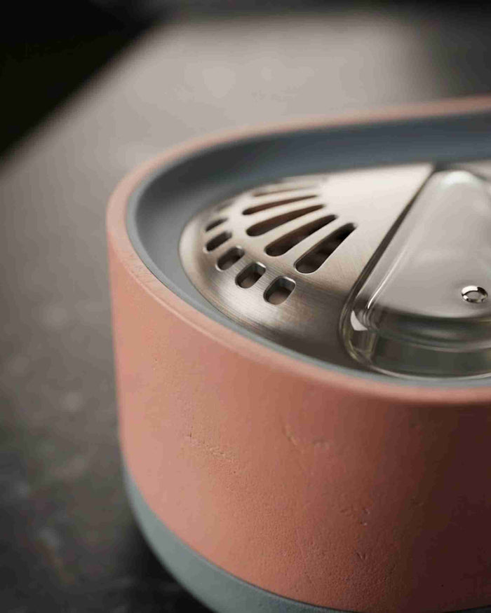 Close-up of pink aroma diffuser vent and stainless top cover on gray base