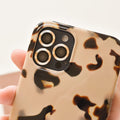 Hand holding smartphone fitted with Coconut Lane gold camera lens covers.
