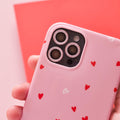 Hand holding a phone with a pink glitter Coconut Lane camera lens cover.