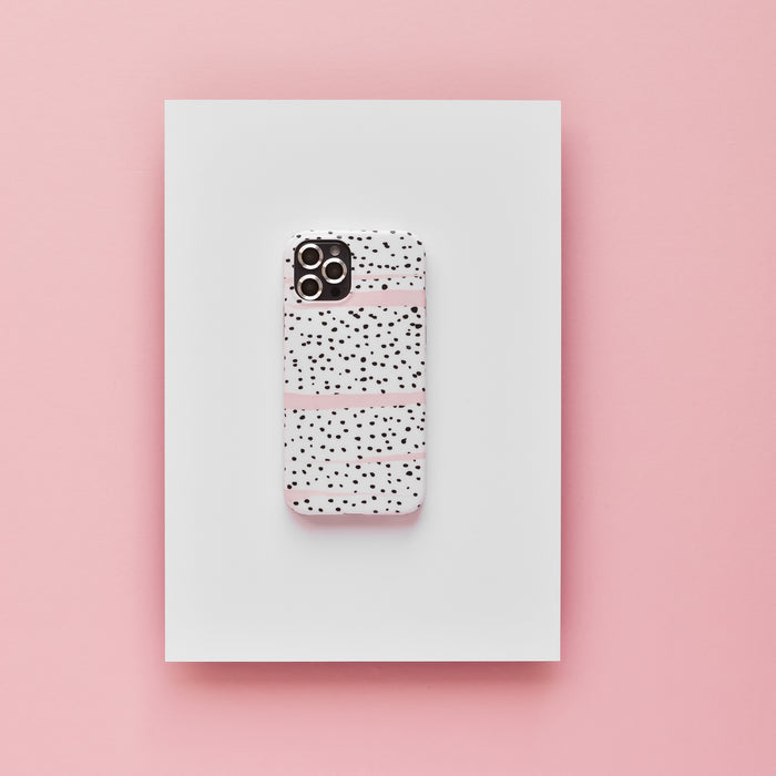 Silver Coconut Lane camera lens covers with a black and white case, displayed on a white rectangle over a pink background.