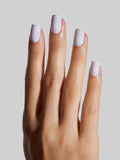 Hand with sky blue press-on nails on a neutral background