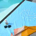 France Laure 1970 beach towel with sunscreen SPF 30 and sunglasses by poolside, ideal for sun protection and summer skincare routines