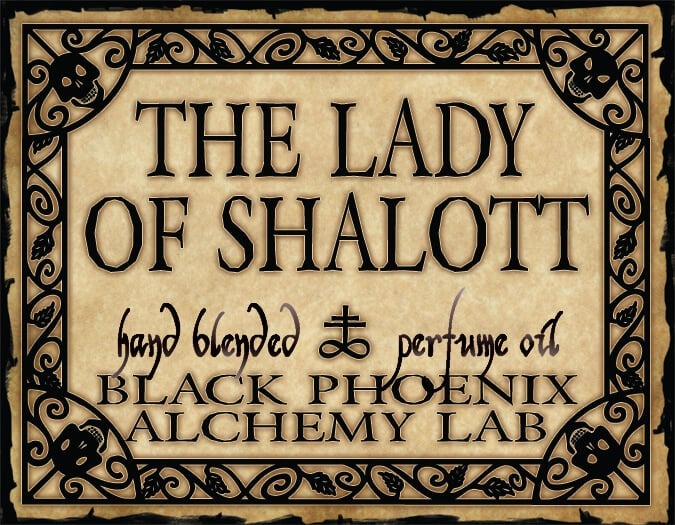 Label for 'The Lady of Shalott' perfume oil by Black Phoenix Alchemy Lab with decorative border.
