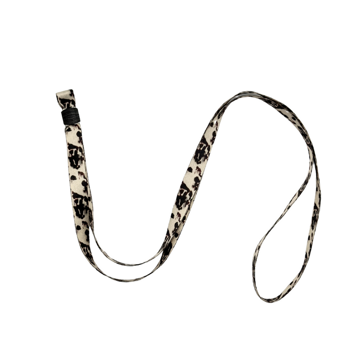A Universal Phone Lanyard Patch Bundle by Coconut Lane, featuring a black and white patterned lanyard with a plastic clip, lies on a plain white background. The fabric lanyard showcases a swirling, abstract design and serves as an essential accessory for added phone security.
