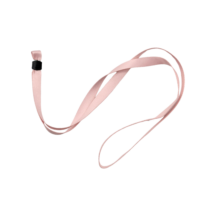 A soft pink ribbon with a black binding at one end, resembling the Coconut Lane Universal Phone Lanyard Patch Bundle, is looped and laid out on a white background.