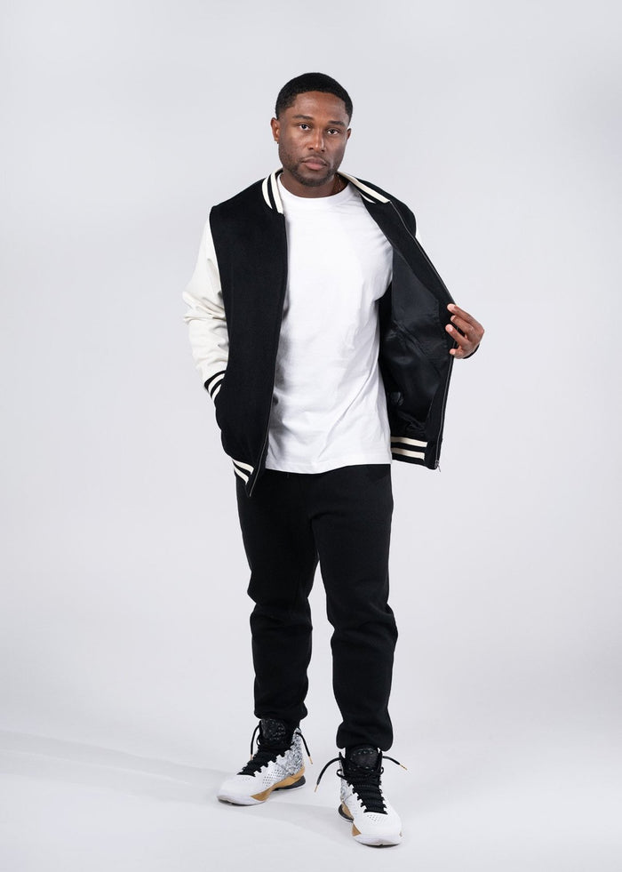 Black and white varsity wool blend jacket with ribbed collar sleeve stripes and zipper front perfect for workwear uniforms